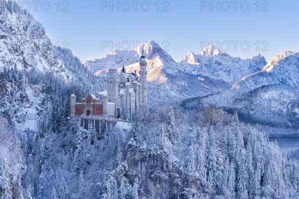 Wintery Neuschwanstein Castle in a snowy mountain landscape. Bright sun rays on the peaks, Schwangau near FÃ¼ssen, OstallgÃ¤u, AllgÃ¤u, Bavaria, Germany