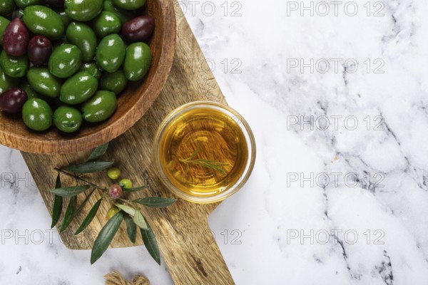 Chalkidiki olives, classic Greek green olives, in a bowl on a cutting board, top view, without people