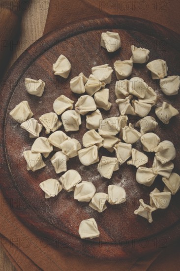 Traditional Turkish dumplings, raw, on a cutting board, top view, no people