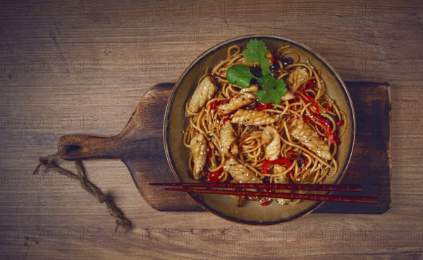 Udon noodles, with squid and vegetables, on a wooden table, homemade, no people