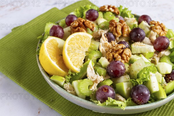 Fresh Waldorf salad, celery stalk with chicken, apple and walnuts, grapes, herbs, homemade, without people