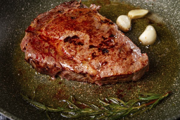 Fried steak, beef steak, rib eye steak, in a frying pan, top view, no people