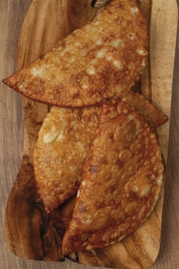 Fried chebureks, close-up, on a wooden chopping board, no people