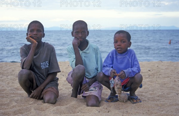 Three local boys posing for the camera on the beach, Chitimba, Lake Malawi, Africa, July 2000, vintage, retro, old, historic