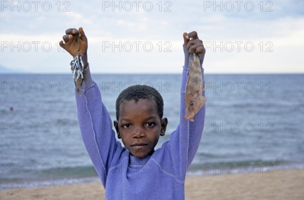 Little boy posing with caught fish for camera, Chitimba, Lake Malawi, Africa, July 2000, vintage, retro, old, historic