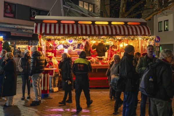 A festively illuminated Christmas market stand with lots of people in a wintry evening mood, Christmas market 2025, Nagold, Black Forest, Calw district, Germany
