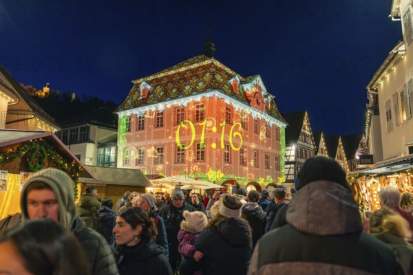 Illuminated building projection showing time at a well-visited Christmas market, Christmas market 2025, Nagold, Black Forest, Calw district, Germany