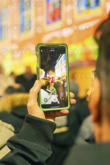 A person records an illuminated event with a smartphone, Christmas market 2025, Nagold, Black Forest, Calw district, Germany