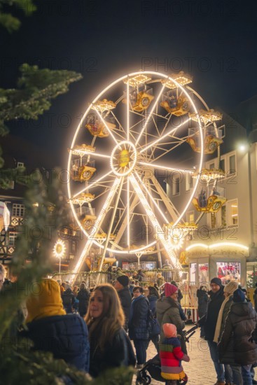A brightly lit Ferris wheel rises above a crowd at a Christmas market, Christmas market 2025, Nagold, Black Forest, Calw district, Germany