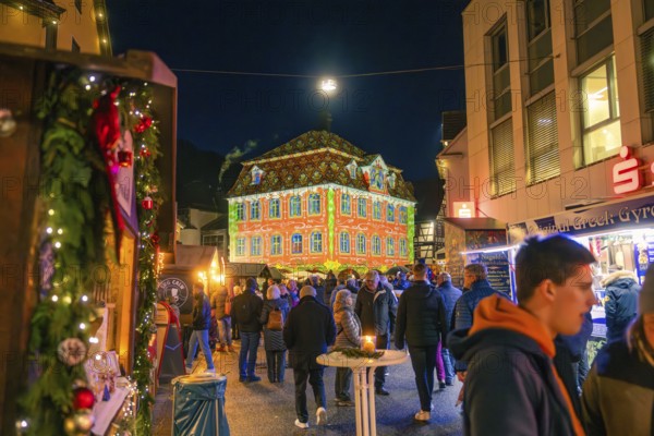 Building with festive light projection on a busy Christmas market, Christmas market 2025, Nagold, Black Forest, Calw district, Germany