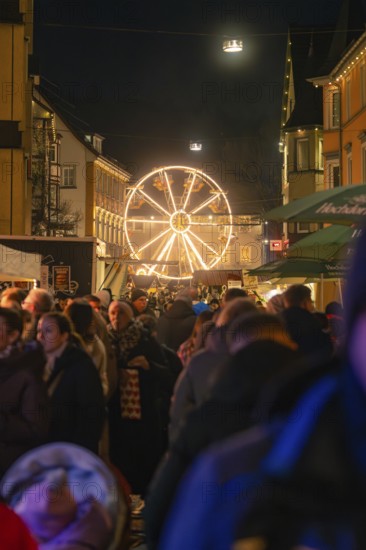 Crowd of people in front of an illuminated Ferris wheel at a municipal Christmas market, Christmas market 2025, Nagold, Black Forest, Calw district, Germany