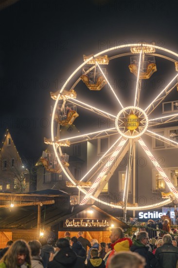 Illuminated Ferris wheel attracts people at a nightly Christmas market, Christmas market 2025, Nagold, Black Forest, Calw district, Germany