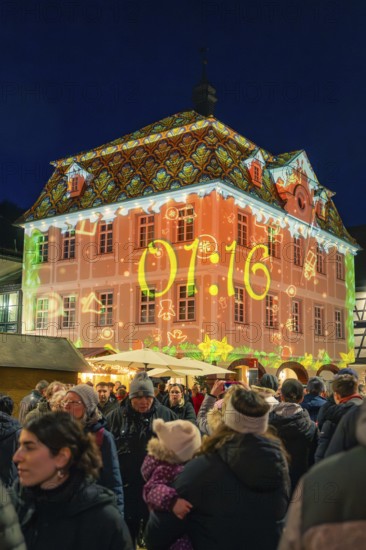 Colourfully illuminated building with time projection on a busy Christmas market at night, Christmas market 2025, Nagold, Black Forest, Calw district, Germany