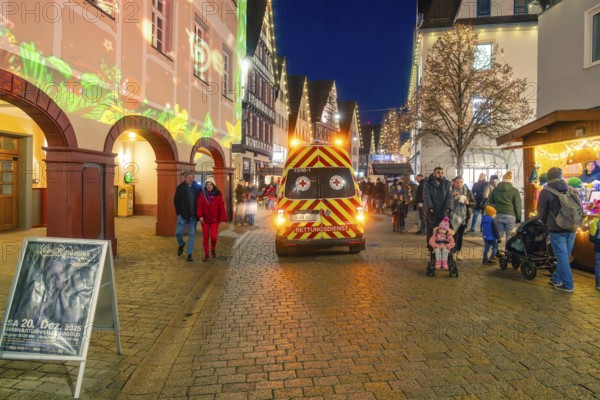 Busy Christmas market at night with rescue service vehicle and festive lighting, Christmas market 2025, Nagold, Black Forest, Calw district, Germany