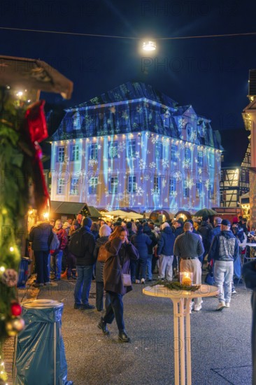 Illuminated building with Christmas projections in front of numerous market visitors, Christmas market 2025, Nagold, Black Forest, Calw district, Germany