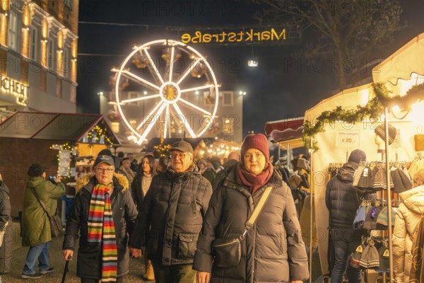 People stroll through an illuminated market with a large Ferris wheel in the background, Christmas market 2025, Nagold, Black Forest, Calw district, Germany