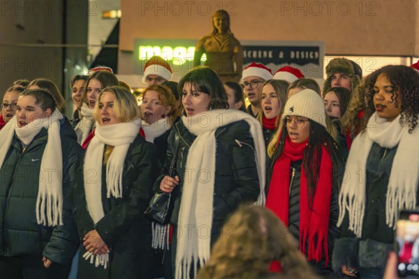 A choir sings outside, the singers wear warm clothes and atmospheric hats and scarves, Christmas market 2025, Nagold, Black Forest, Calw district, Germany