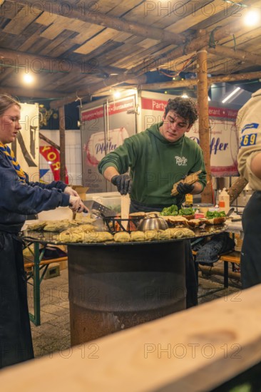 Chefs at the stand prepare fresh pancakes at a Christmas market, Christmas market 2025, Nagold, Black Forest, Calw district, Germany