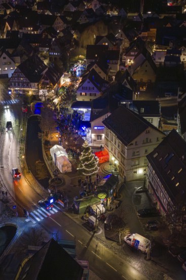Aerial view of an illuminated Christmas market at night with a shiny Christmas tree and crowds of people, Aidlingen Christmas market, BÃ¶blingen district, Germany
