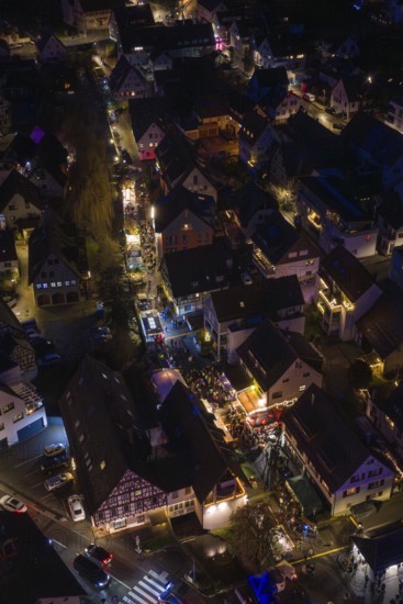 Village at night with tight street lights and festive lights, Aidlingen Christmas market, Böblingen district, Germany