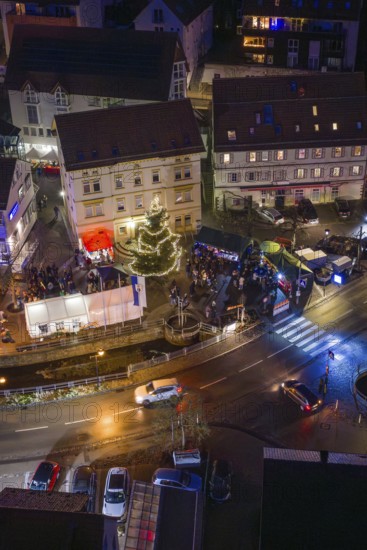 Night view with decorated Christmas tree and people gathered, Aidlingen Christmas market, Böblingen district, Germany