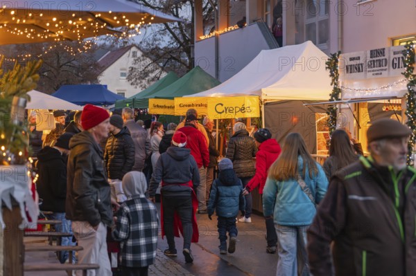 Crowd of people at a cozy Christmas market in the evening, Aidlingen Christmas market, Böblingen district, Germany
