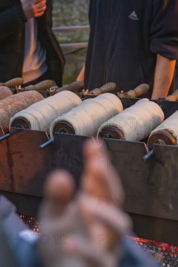 Fresh pastries are baked over an open fire at a market stand, Aidlingen Christmas Market, Böblingen District, Germany