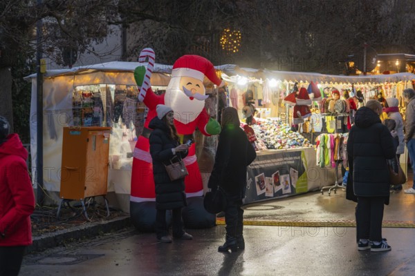 Christmas market with Santa Claus decoration and illuminated stalls in the evening, Aidlingen Christmas market, Böblingen district, Germany