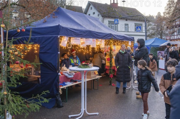 Visitors walk past a tent with Christmas lights and decorations at a Christmas market, Aidlingen Christmas market, Böblingen district, Germany