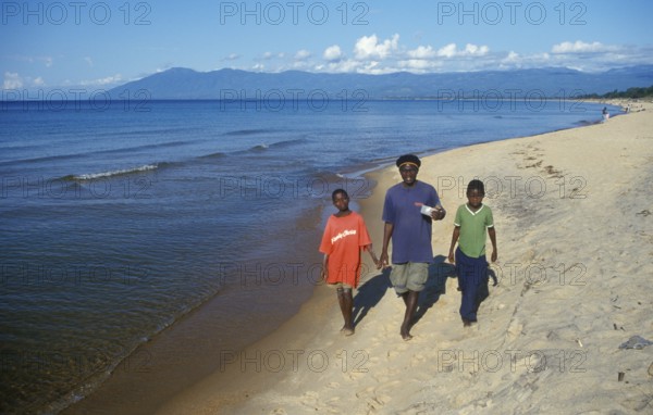 Two boys and a young man stroll along Kande Beach on Lake Malawi, Malawi, Africa, July 2000, vintage, retro, old, historic