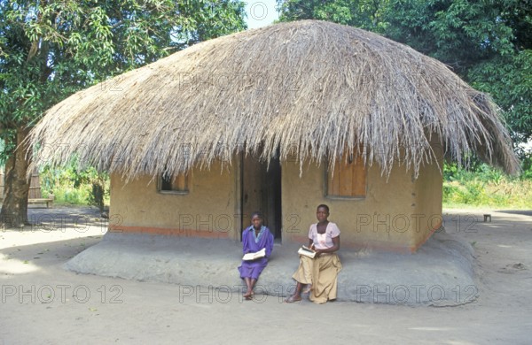 Two woman in front of a thatched house near Kande, Lake Malawi, Africa, July 2000, vintage, retro, old, historic