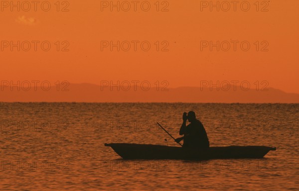 Sunrise over Lake Malawi, man in dugout, Kande, Malawi, Africa, July 2000, vintage, retro, old, historic