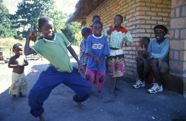 Local children dance happily to music in a village near Kande, Lake Malawi, Malawi, Africa, July 2000, vintage, retro, old, historic