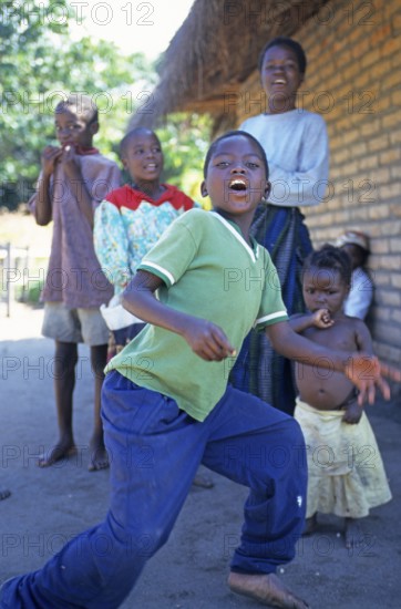 Local children dance happily to music in a village near Kande, Lake Malawi, Malawi, Africa, July 2000, vintage, retro, old, historic