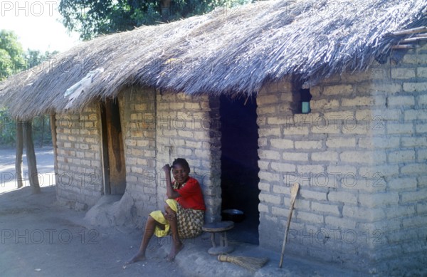 Woman sitting in front of a house in a village near Kande on Lake Malawi, Malawi, Africa, July 2000, vintage, retro, old, historic