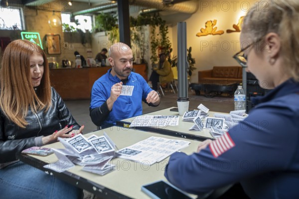 Detroit, Michigan - Volunteers with the Detroit Peoples Assembly put together whistle kits. The whistles are designed to alert others in the community when immigration agents are nearby. These volunteers are preparing a bilingual sheet of tips for dealing with immigration agents