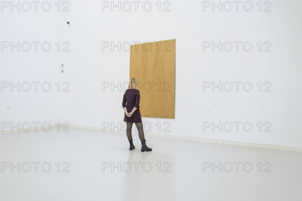 Woman looking at a large, simple, wooden work of art in a minimalistic space, Open Horizons exhibition, Schauwerk Sindelfingen, Böblingen district, Germany