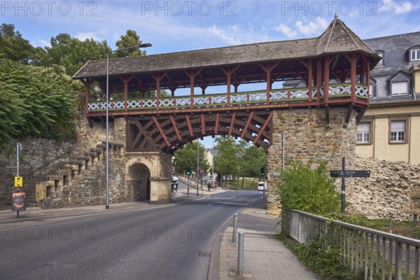 Historic city fortification, historicizing city gate Römertor, historic city wall Heidenmauer, street, barrier bollard, lantern, trees, bushes, blue sky, cirrus clouds, CoulinstraÃŸe, Wiesbaden, state capital, district-free city, Hesse, Germany