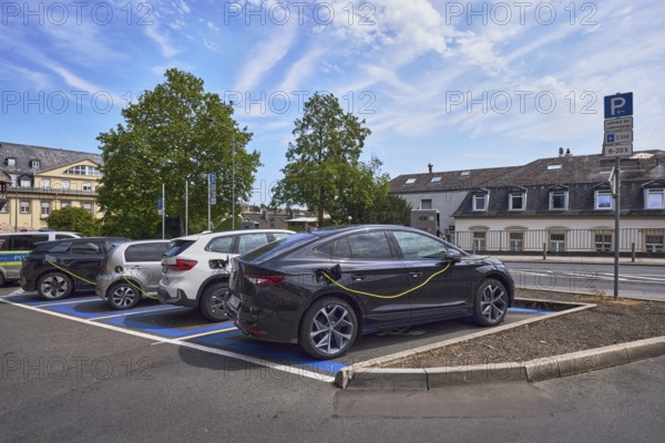 Parking lot, electric car, e-car with charging cable, general architecture, trees, blue sky, altocumulus clouds, cirrus clouds, diffuse light, slightly sunny, CoulinstraÃŸe, Wiesbaden, state capital, district-free city, Hesse, Germany