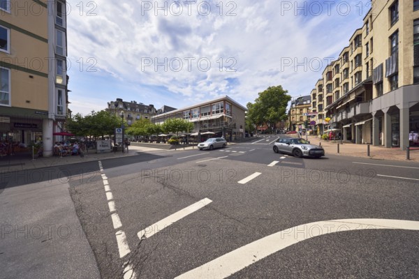General architecture, residential and commercial buildings, modern architecture, pedestrian zone, pedestrian crossing, roads, trees, cars, vehicles, pedestrians as a secondary theme, blue sky, cumulus clouds, cirrostratus clouds, slightly diffused light, milky blue sky, intersection of Langgasse, Webergasse and Kranzplatz, Wiesbaden, state capital, district-free city, Hesse, Germany