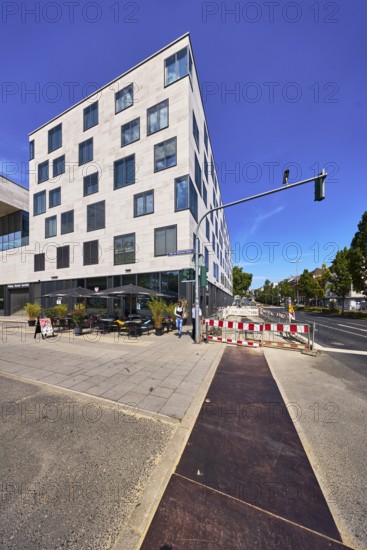 Commercial building, modern architecture, outdoor area of a restaurant, waffle house, fenced construction site, barrier, road construction, traffic lights, pedestrians as accessories, deep blue sky, cirrus clouds, intersection of Schwalbacher StraÃŸe with German Unity Square, Wiesbaden, state capital, district-free city, Hesse, Germany