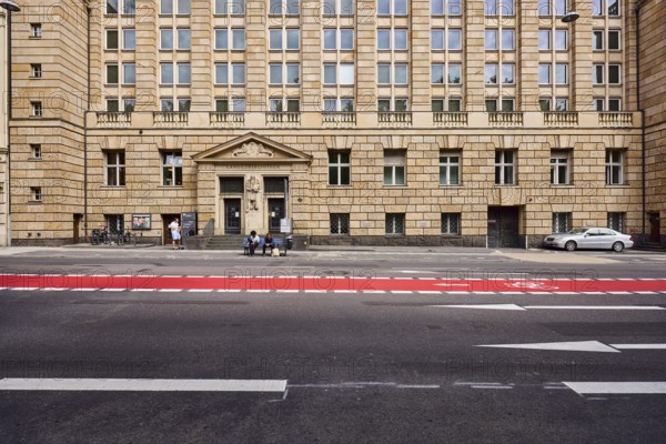 Hochschul- und Landesbibliothek RheinMain, university library, library, building, entrance, faÃ§ade with windows and entrance door, bus stop Landesbibliothek, lanes, cycle path, road markings direction arrow, people waiting for means of transport, sunny, RheinstraÃŸe, Wiesbaden, state capital, district-free city, Hesse, Germany