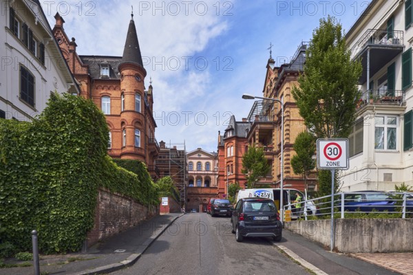 Houses, historic residential buildings, concrete wall, brick wall, trees, hedge, zone 30 sign, blue sky, cumulus clouds, street An der alten Synagoge, Wiesbaden, state capital, district-free city, Hesse, Germany