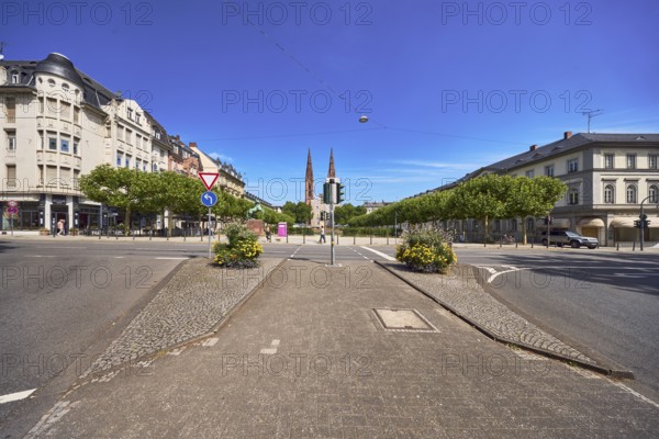 Traffic island, roads, square, St. Boniface Catholic Church, scaffolding, renovation, barrier bollard, pedestrian crossing, traffic lights, traffic signs, right of way, prescribed direction of travel left, flower pots, general architecture, houses, buildings, trees, blue sky, cirrus clouds, intersection RheinstraÃŸe with Luisenplatz and AdolfstraÃŸe, Wiesbaden, state capital, district-free city, Hesse, Germany