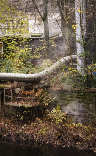 District heating pipeline in front of old industrial buildings on the banks of the Wupper, Wuppertal, Germany