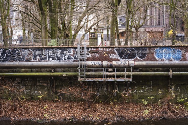 District heating pipeline in front of old industrial buildings on the banks of the Wupper, Wuppertal, Germany