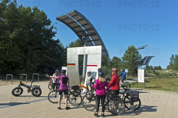Cyclists at the symbolic gate on the border between Germany and Poland on the Europa Promenade, Ahlbeck, Usedom island, Mecklenburg-Western Pomerania, Germany
