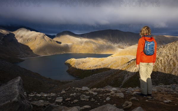 Hiker at Upper Tama Lake, Tama Lake Walk (Tama Lakes Track), evening light, golden hour, Tongariro National Park, North Island, New Zealand