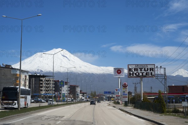 Road with passing vehicles flanked by a hotel and snow-capped mountains in the background, Great Ararat, BÃ¼yÃ¼k AÄŸrÄ± DaÄŸÄ±, Dogubayazit, DoÄŸubayazÄ±t, Dogubeyazit, Agri Province, Eastern Anatolia, Anatolia, Turkey