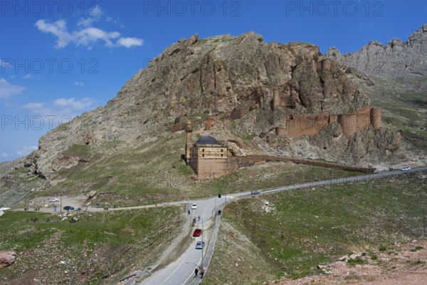 A fortress on a mountain with a road and cars in the foreground under a clear blue sky, Eski BayezÄ±d Cami, Old Bayezid Mosque and DoÄŸubayazÄ±t Castle, Dogubayazit, DoÄŸubayazÄ±t, Agri Province, AÄŸrÄ±, Eastern Anatolia, Anatolia, Turkey